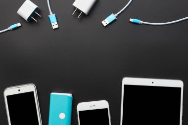 siyah adam üzerinde pil banka ve şarj kablosu ile Smartphone
