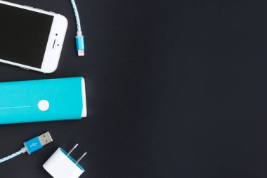 Üstten Görünüm USB kablosu beyaz smartphone ve mavi pilin şarj edilmesi