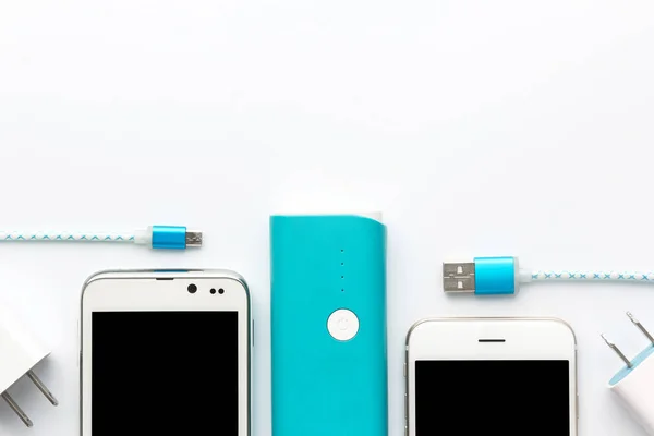 top view of usb charging cable white smartphone and blue battery