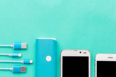 Üstten Görünüm USB kablosu beyaz smartphone ve mavi pilin şarj edilmesi