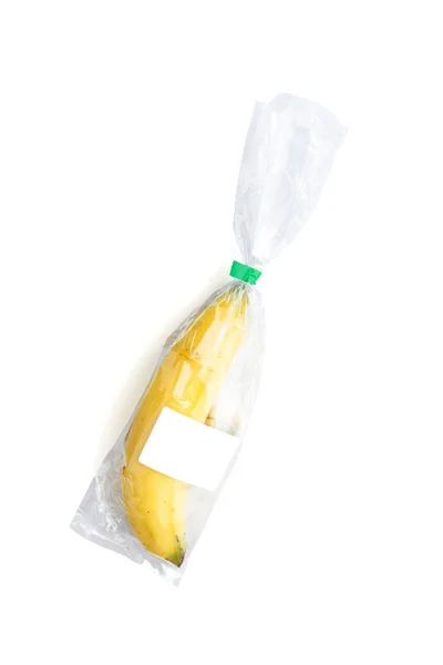 Banana amarela em saco de plástico com banner em branco para texto em branco — Fotografia de Stock