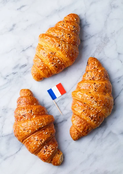 Croissants with French flag. Marble background. Top view