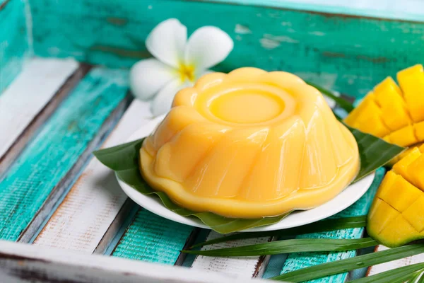 Mango pudding, jelly on white plate with palm leaf