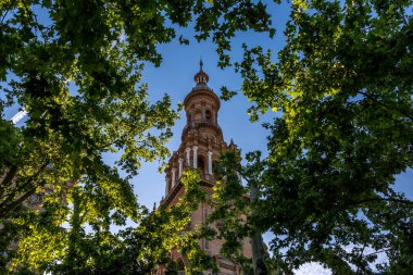 A shot through the trees of one of the Towers at the Plaza de Espaa (translated to Spain Square) which is found in the Parque de Maria Luisa in Seville, Andalucia in Southern Spain.