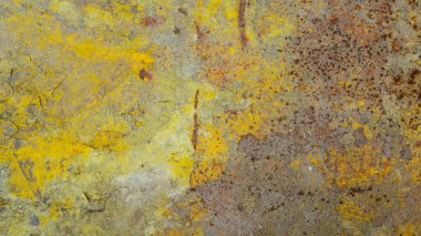 Old cracked paint on yellow wall, textured patterned background.