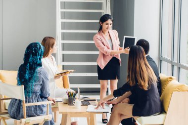 Bir grup Asyalı genç iş arkadaşı takım tartışması, girişim projesi toplantısı ya da mutlu takım çalışması beyin fırtınası konsepti.