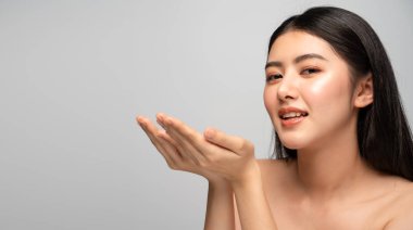 Tender Asian woman with natural makeup and beautiful hair posing with cupped hands
