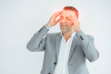 Başı ağrıyan bir iş adamı. Beyaz arka planda izole edilmiş bir adam baş ağrısı yüzünden parmaklarını şakaklarına sürtüyor..