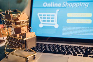 Çevrimiçi alışveriş ve iot (şeylerin interneti) kavramı. Dizüstü bilgisayarda bir tramvayda kutular. Çevrimiçi alışveriş ve çevrimiçi alışveriş fikirleri tüketicilerin İnternet üzerinden doğrudan bir satıcıdan mal satın almalarıdır.