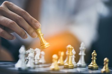 Güzel Asyalı iş kadını satranç oyununda satranç figürlerini hareket ettiriyor. İş stratejisi ve taktik kavramı, iş planı, takım çalışması, başarı.