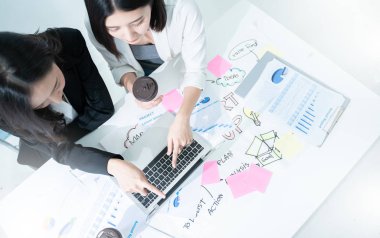 Başarılı ve Takım çalışma süreci kavramı. Açık uzay ofisinde dizüstü bilgisayarı olan iki kadın. Güneş parlaması ve film efekti. Boşluğu kopyala.