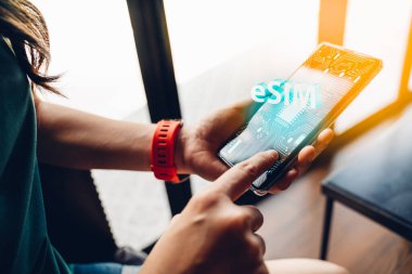 ESIM teknolojisi olan bir telefon kullanan kadına yakın çekim. Devre kartında bir çip olan mobil cihaz art.eSIM (Gömülü SIM) - Elektronik simülasyon telefon yeni mobil iletişim teknolojisi.