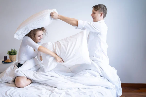 Jovem Casal Bonito Divertindo Juntos Cama Enquanto Tendo Travesseiro Luta — Fotografia de Stock