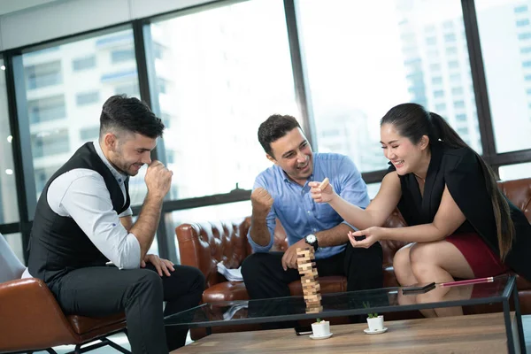 Strategy, risk and Planning in business, businessman placing wooden block on a tower. Businessman and businesswoman meeting in office.Business People meeting Planning Strategy Analysis Concept.