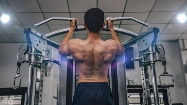 Athletic muscular bodybuilder training in gym, strong male.