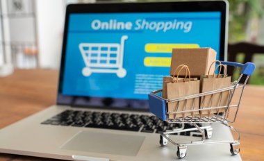 Çevrimiçi alışveriş ve iot (şeylerin interneti) kavramı. Dizüstü bilgisayarda bir tramvayda kutular. Çevrimiçi alışveriş ve çevrimiçi alışveriş fikirleri tüketicilerin İnternet üzerinden doğrudan bir satıcıdan mal satın almalarıdır.