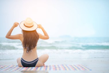 Kadın cennette tropikal sahilde su kenarında eğleniyor..