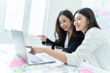 Başarılı ve Takım çalışma süreci kavramı. Açık uzay ofisinde dizüstü bilgisayarı olan iki kadın. Güneş parlaması ve film efekti. Boşluğu kopyala.