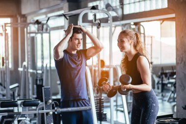 Spor, spor, spor, spor, takım çalışması, halter ve insan konseptinde halterci olan genç çiftler. Fitness kızı sabah dambılı kaldırıyor. Sağlık konsepti değişikliği.
