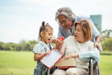 Asya aile kavramı. Büyükanne, büyükbaba ve torun bahçede eğlendiler. Büyükannenin Noel hediyeleri..
