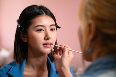 Güzellik konsepti. Makyaj sanatçısı güzellik stüdyosunda çalışıyor. Makyaj süreci, doğal makyaj, yüz bakımı, kuaförde fırça, pudra ve renk modeli kullanarak mükemmel bir cilt makyajı sanatçısı..