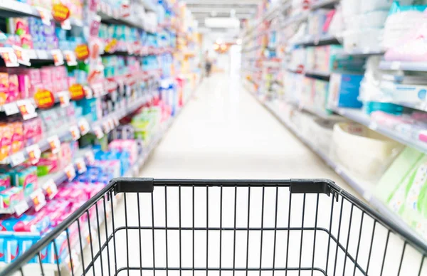 shopping in a supermarket concept.Shopping in supermarket a shopping cart view with motion blur.Close up of a woman shopping in a supermarket.Customer pushing a shopping cart in a supermarket.