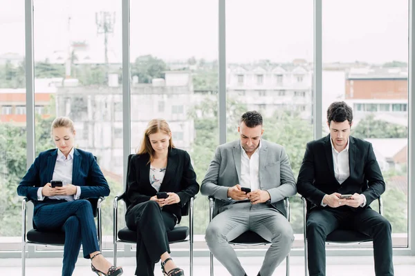 Bir grup iş adamı başkanlık yapıyor ve cep telefonlarını kullanıyor, işi ve sosyal ağları görmezden geliyorlar..