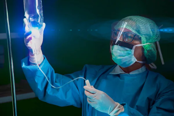 Male doctor checking a saline drip in hospital.Doctor operation in operation room at hospital concept for insurance advertising.hospital brochures.flare light.