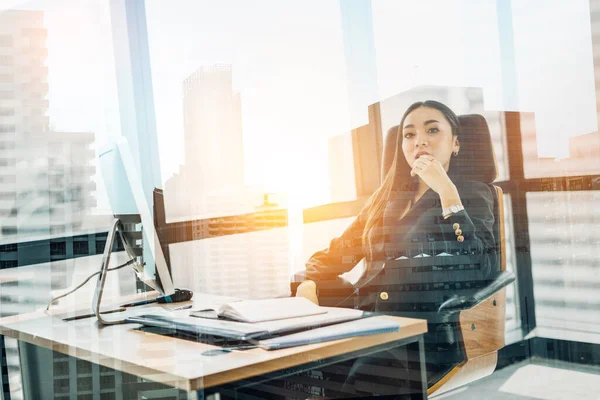 Portrait of relaxed business woman in office.smiling asian businesswoman sitting in office looking at the camera.