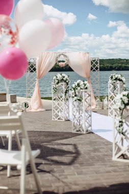 Düğün töreni güneşli bir pembe tonlarında bir göl kıyısında