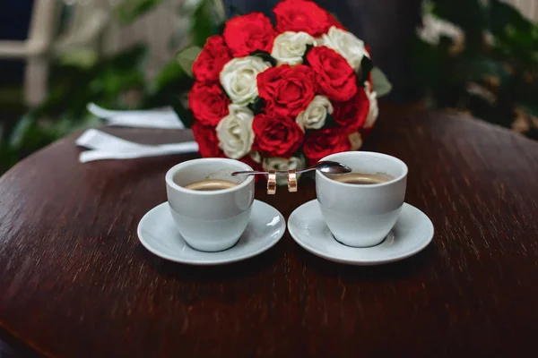 wedding bouquet and coffee with the wedding rings