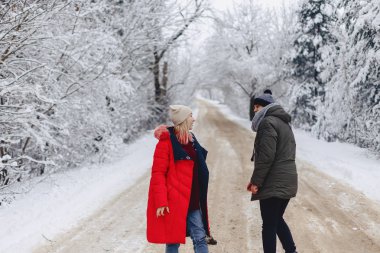 Ormanın içinde karlı bir yolda yürüyen güzel bir aile Çift