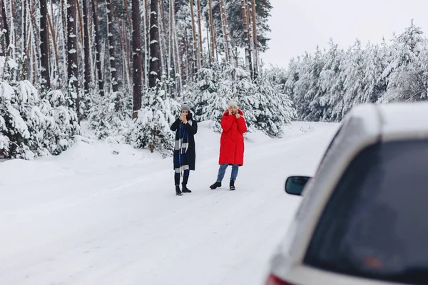 Meisjes in het midden van de weg praten aan de telefoon met de auto op een — Stockfoto