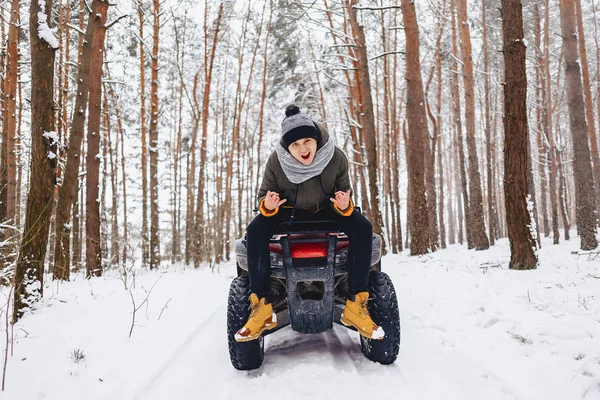 Een jongen is permanent in de buurt van een quad bike midden in het bos — Stockfoto