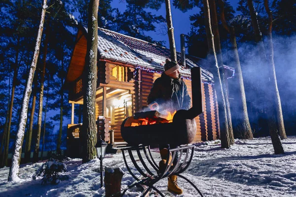 A man fries grilled meat against the background of the cottage i — Stock Photo, Image