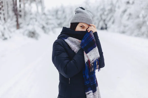 Une fille portant un chapeau d'hiver pose sur une caméra en arrière-plan — Photo