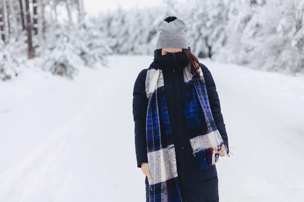 Uma menina usando um chapéu de inverno posa em uma câmera no fundo — Fotografia de Stock