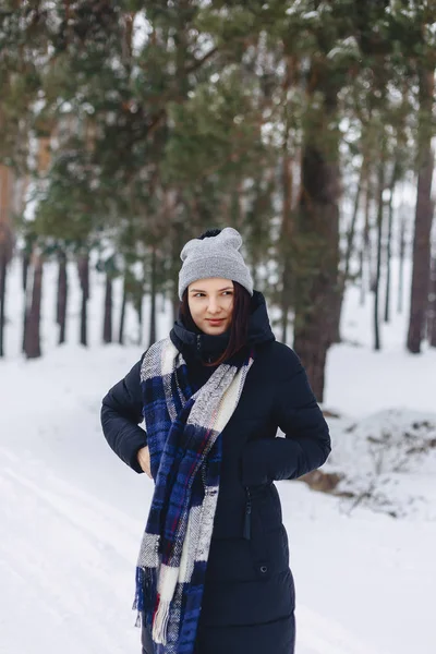 A girl wearing a winter hat poses on a camera in the background — Stock Photo, Image