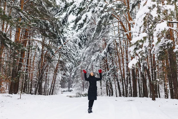 La fille se promène dans une forêt enneigée parmi les pins en rouge g — Photo