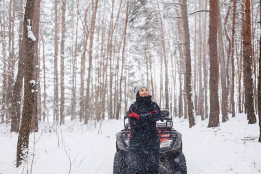 karla kaplı çam ormanı içinde bir motosiklet üzerinde genç kız rides 