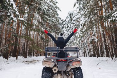 karla kaplı çam ormanı içinde bir motosiklet üzerinde genç kız rides 