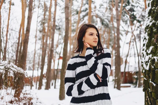Jovem menina em suéter preto e branco no frio na floresta — Fotografia de Stock