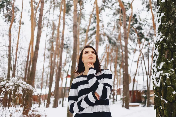 Jovem menina em suéter preto e branco no frio na floresta — Fotografia de Stock