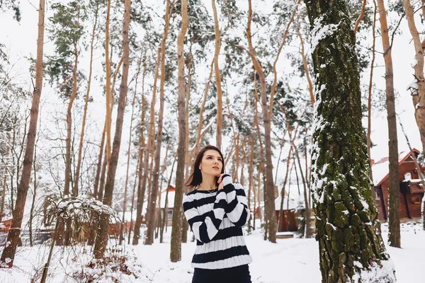 Jeune fille en pull noir et blanc dans le froid à la forêt — Photo