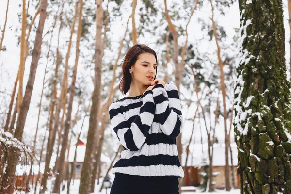 Jeune fille en pull noir et blanc dans le froid à la forêt — Photo