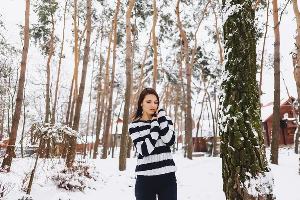 Jovem menina em suéter preto e branco no frio na floresta — Fotografia de Stock