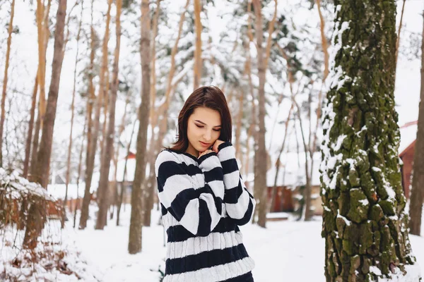 Jovem menina em suéter preto e branco no frio na floresta — Fotografia de Stock