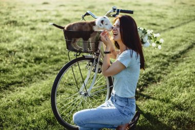 Kız ile bir köpek yavrusu bir bisiklet arka alanına yürüyor 