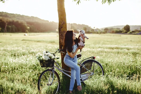 여자 뒤에 자전거에 필드에 강아지와 함께 산책 — 스톡 사진