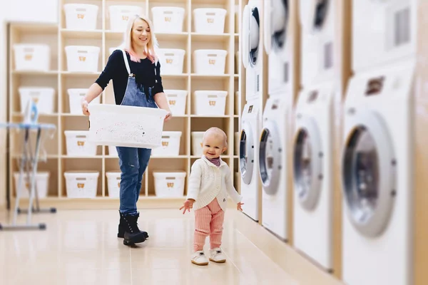 Mamma och baby i tvätten ta saker och spela — Stockfoto